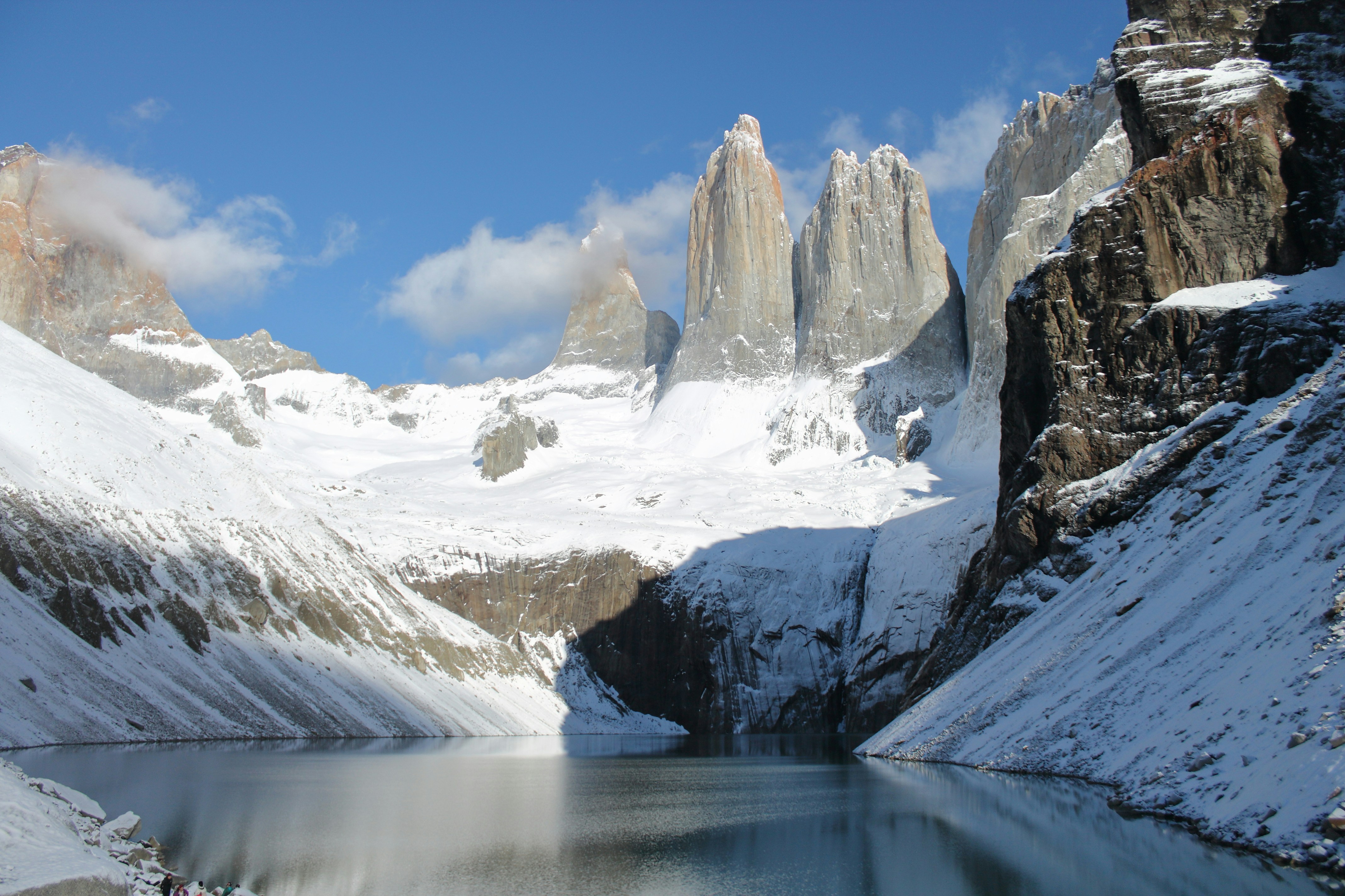 Torres del Paine cobertas de neve com lago na base